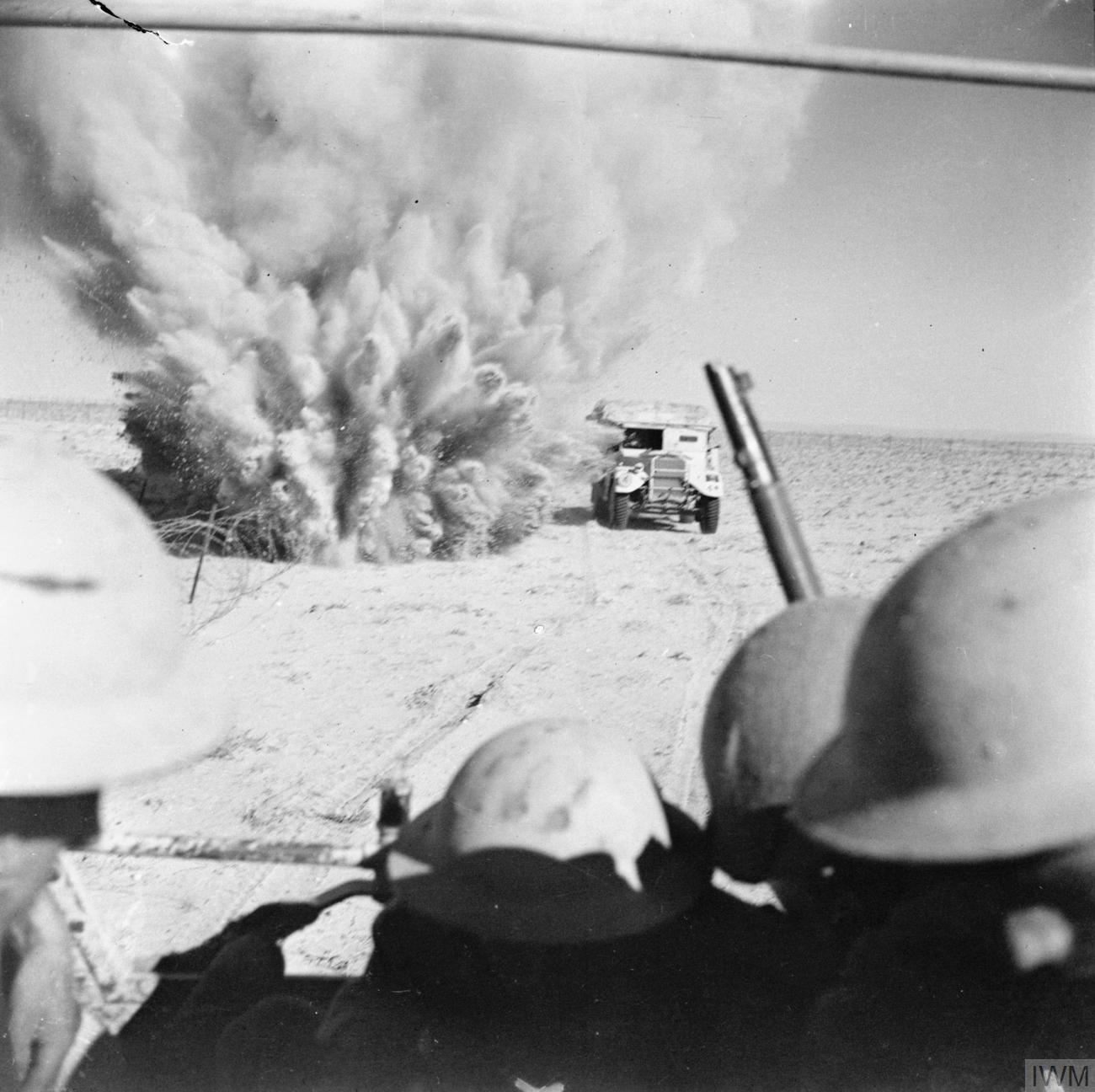 A mine explodes near a British truck carrying infantry through the minefields.