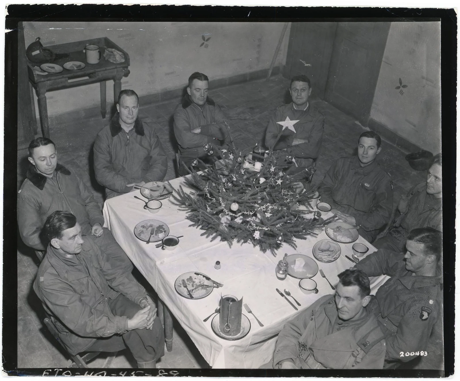 American officers seated around a Christmas dinner table at Bastogne