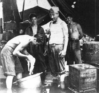 Marines working in a flooded field kitchen at Cape Gloucester