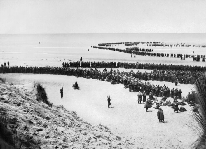 British troops wait on the beach at Dunkirk, May 1940. Wartime photograph, IWM NYP 68075; public domain via Wikimedia Commons.
